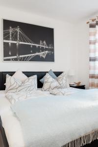 a white bed with a black and white picture on the wall at Pension Kohlweg - Free Parking, Garden and air conditioning in Graz