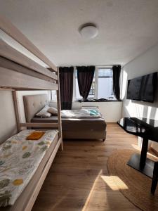 a bedroom with two bunk beds and a desk at Bay Fewo in Rosenheim