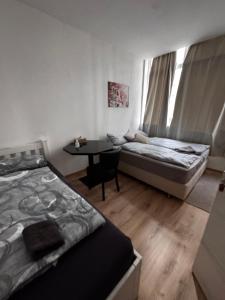 a bedroom with two beds and a table in it at Bay Fewo in Rosenheim