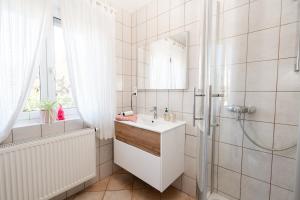 a white bathroom with a sink and a shower at Pension Kohlweg - Free Parking, Garden and air conditioning in Graz +67 photos