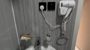 a bathroom sink with a hair dryer and a phone at غنى الأفق in ‘Afīf