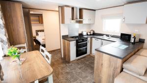 a small kitchen with a table and a dining room at 6. Supreme OD 2 Caravan with Decking in Ringwood