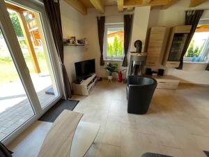 a living room with a television and a living room with doors at Villa Sonnenblick in Kötschach