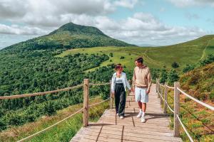 a man and a woman walking on a wooden bridge at Les Cactus #MaisonSavaron - 52m2 - Terrasse in Clermont-Ferrand