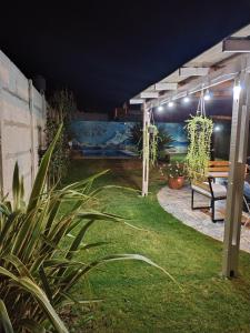 a garden at night with a bench under a pergola at La Candela in Olavarría