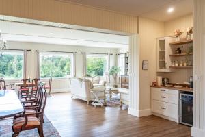 a kitchen and living room with a table and chairs at Woodside Farm Country Inn in Sooke
