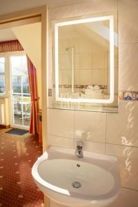 a bathroom with a sink and a mirror at Hotel Ostseeblick - direkt hinter den Dünen in Karlshagen +124 photos
