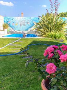 a garden with a hose and flowers in the grass at La Candela in Olavarría