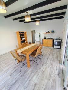 a dining room table with chairs and a kitchen at La Candela in Olavarría