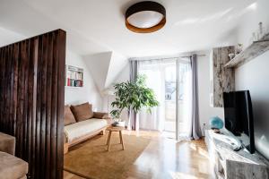 a living room with a couch and a tv at Pension Kohlweg - Free Parking, Garden and air conditioning in Graz