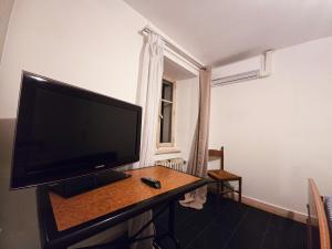 a flat screen tv sitting on a table in a room at Chez ValJean in Châlus +1 photo