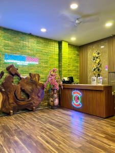 Ein Eingangsbereich mit Theke und Blumen in der Unterkunft Louise Hotel in Glugur