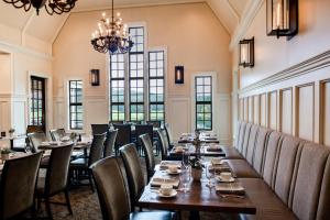a dining room with tables and chairs and a chandelier at Barnsley Resort in Adairsville
