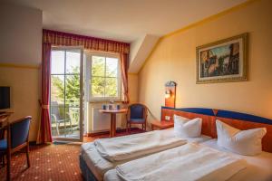 a hotel room with a bed and a window at Hotel Ostseeblick - direkt hinter den Dünen in Karlshagen