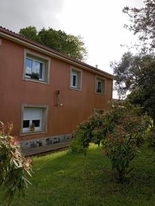 a house with a tree in front of it at A Casa do San Paio de Buscás in Ordes