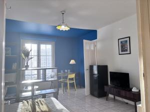 a living room with blue walls and a dining room at Nuit Panoramique - Studio - Wifi - 2 pers in Châtel-Guyon