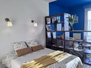 a bedroom with a bed and a blue wall at Nuit Panoramique - Studio - Wifi - 2 pers in Châtel-Guyon +10 photos