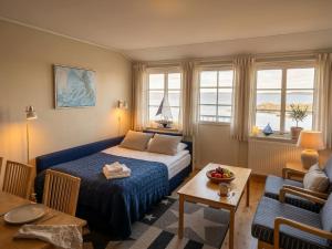 a bedroom with a bed and a table and a couch at Ekenäs Havshotell Koster in Sydkoster