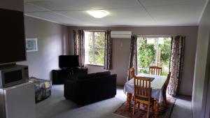 a living room with a couch and a table and chairs at Mahoe Motel in Taumarunui