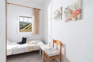 a bedroom with a bed and a desk with a laptop at GARDEN HOUSE, Kalamaki in Tympáki +78 photos