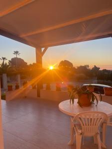a table on a patio with a sunset in the background at Villa le Locle in Alicante
