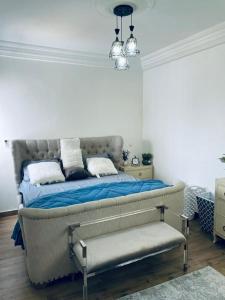 a bedroom with a bed with blue sheets and white pillows at Zac Mbao appartement meuble in Mbaw