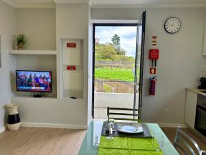 a dining room with a table and a clock and a window at Maria s Guest House, By OP in Ponta Delgada