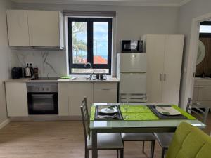 a kitchen with a table and a table and chairs at Maria s Guest House, By OP in Ponta Delgada +7 photos