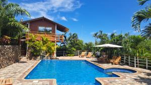 a villa with a swimming pool in front of a house at Marybutch in Manglaralto