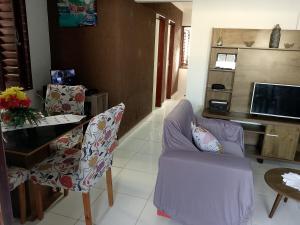 a living room with a purple chair and a table at Casa praia de Barra nova 6 km de Maceió in Marechal Deodoro