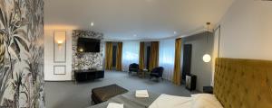 a hotel room with a bed and a television at Stara Palmiarnia Mimoza in Rybnik