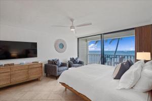 a bedroom with a large bed with a view of the ocean at Lahaina203 in Lahaina +17 photos
