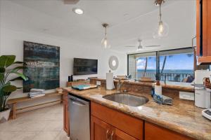 a kitchen with a sink and a view of the ocean at Lahaina203 in Lahaina