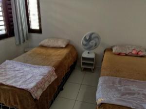 a bedroom with two beds and a fan at Casa praia de Barra nova 6 km de Maceió in Marechal Deodoro