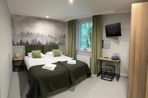 a bedroom with a large bed and a window at Stara Palmiarnia Mimoza in Rybnik
