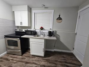 a kitchen with a sink and a stove at Modern Comfort Haven Near Reversing Falls Bridge Saint John NB in Saint John +52 photos