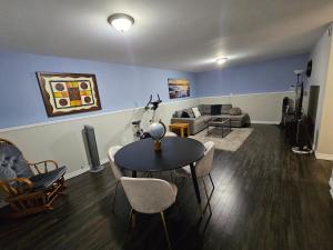 a living room with a table and chairs and a couch at Modern Comfort Haven Near Reversing Falls Bridge Saint John NB in Saint John