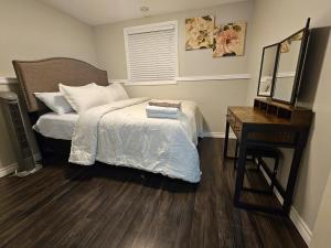 a bedroom with a bed and a desk and a mirror at Modern Comfort Haven Near Reversing Falls Bridge Saint John NB in Saint John