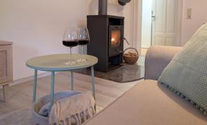 two glasses of wine on a table in front of a stove at Oberlausitz Glück - gemütliche Ferienwohnung in ruhiger Lage mit Garten und Kamin in Sohland