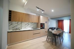 a kitchen and dining room with a table and chairs at Hotel Apart Odeon in Durrës