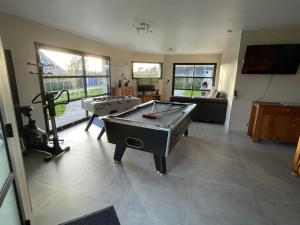 a living room with a ping pong table and a pool table at GITE DE L'ORCHIDÉE P M r in Locmaria-Grand-Champ