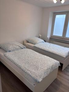 two twin beds in a room with a window at Ferienwohnung in Hackenheim +2 photos