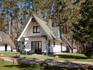 a white house with a gambrel roof at Ferienhäuser im Naturresort Drewitz in Drewitz