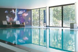 a swimming pool in a house with a painting on the wall at Ferienhäuser im Naturresort Drewitz in Drewitz