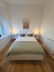 a bedroom with a large bed with two tables at 2 Bed Apartment with Harbour Views Apt 2 in Cobh