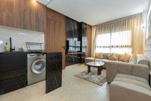 a living room with a couch and a washing machine at Elite Home in Maarif