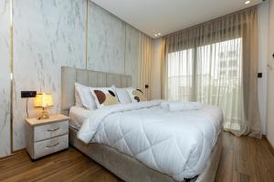 a bedroom with a large white bed and a window at Elite Home in Maarif