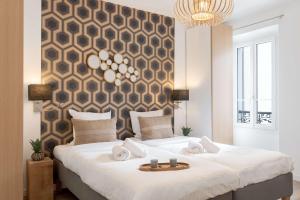a bedroom with a large white bed with a chandelier at Totolulu Cannes Luxury Properties in Cannes