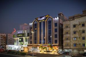 a building with a sign on top of it at night at شاطئ الحياة للشقق المخدومة in Jeddah