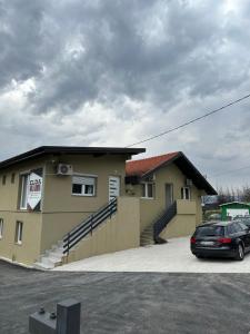 a house with a car parked in front of it at Apartments Aventra in Visoko